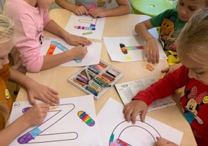Dzieci kolorują literkę